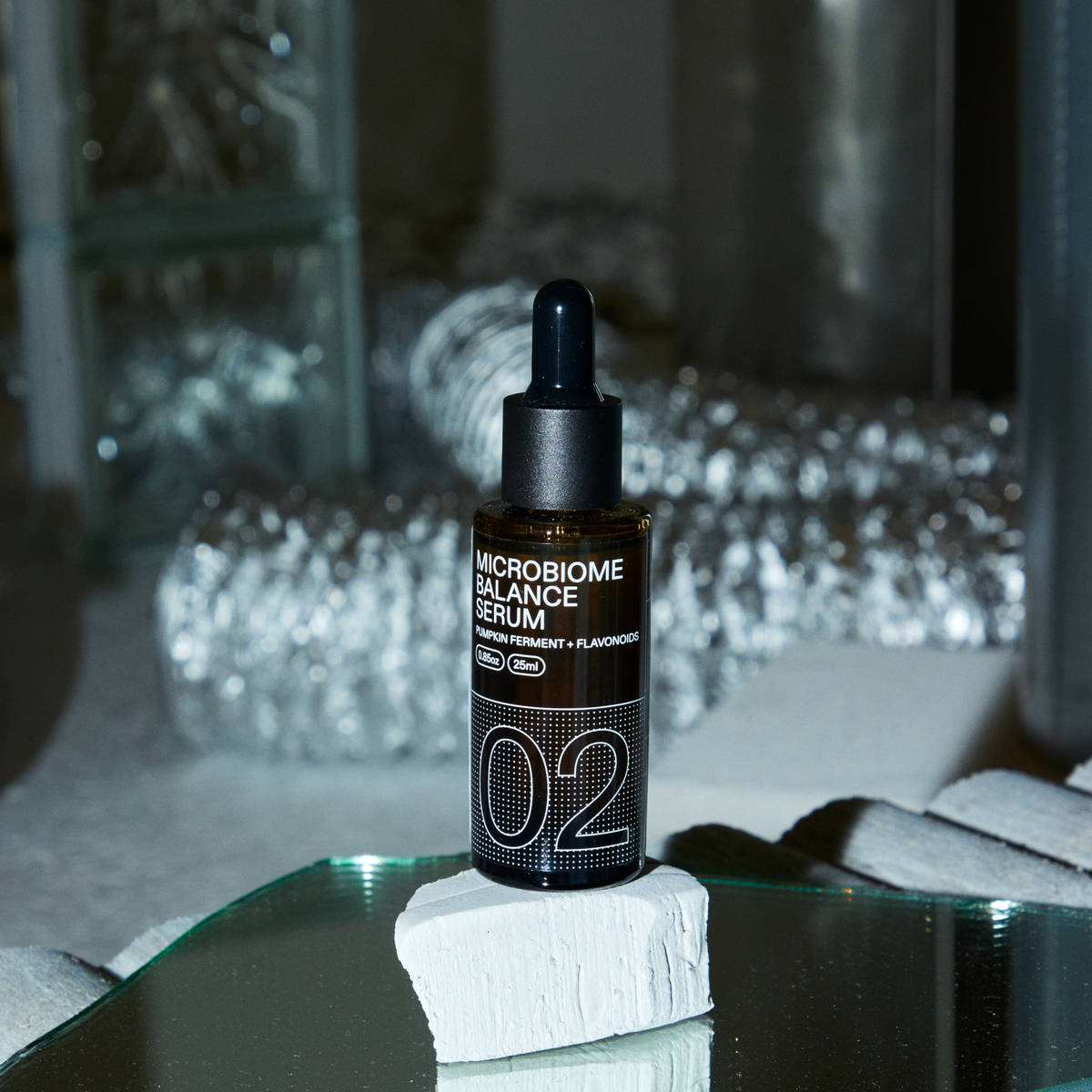 Frasco de Routinely 02 Microbiome Balance de 25 ml sobre un soporte