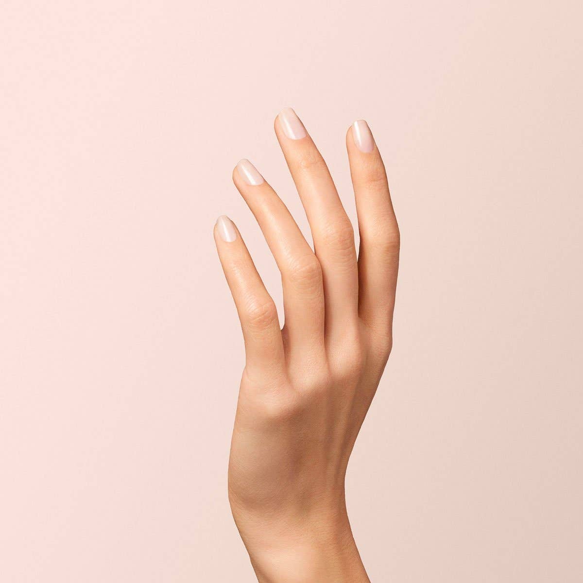 Uñas efecto porcelana con el color Blanco Lechoso de Manucurist resaltando con joyería fina.