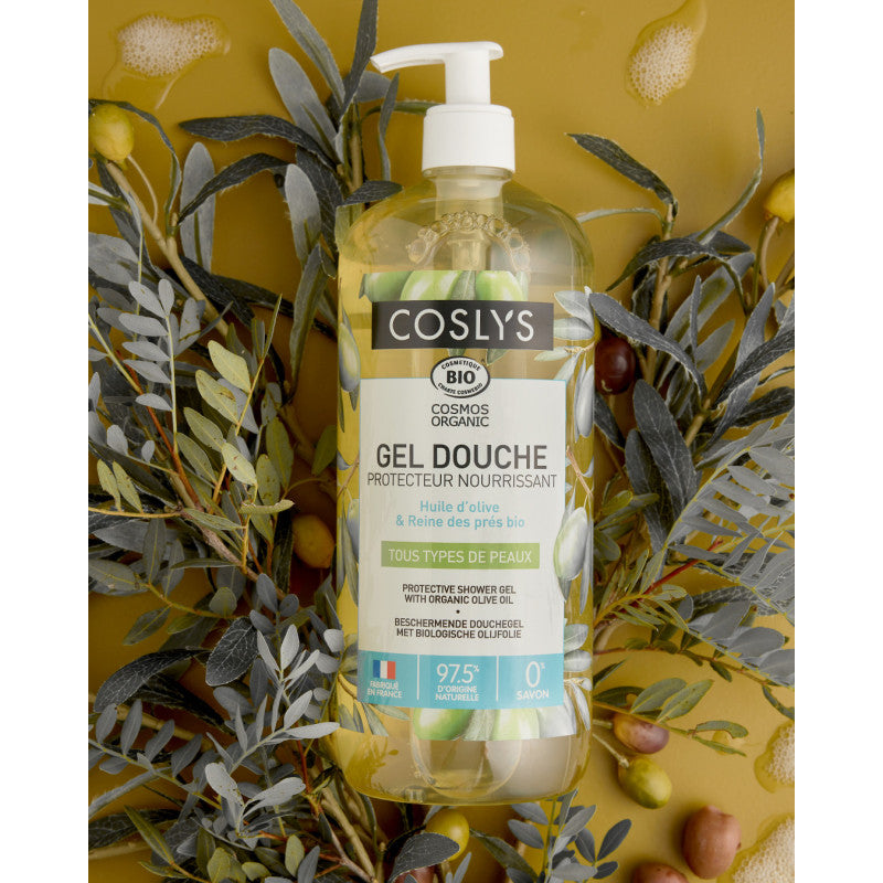 Botella con dosificador del gel de ducha de oliva Coslys entre ramas y aceitunas