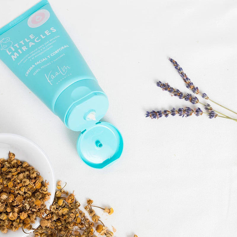 Tubo abierto de Little Miracles de Kaalm Organics junto a manzanilla y lavanda
