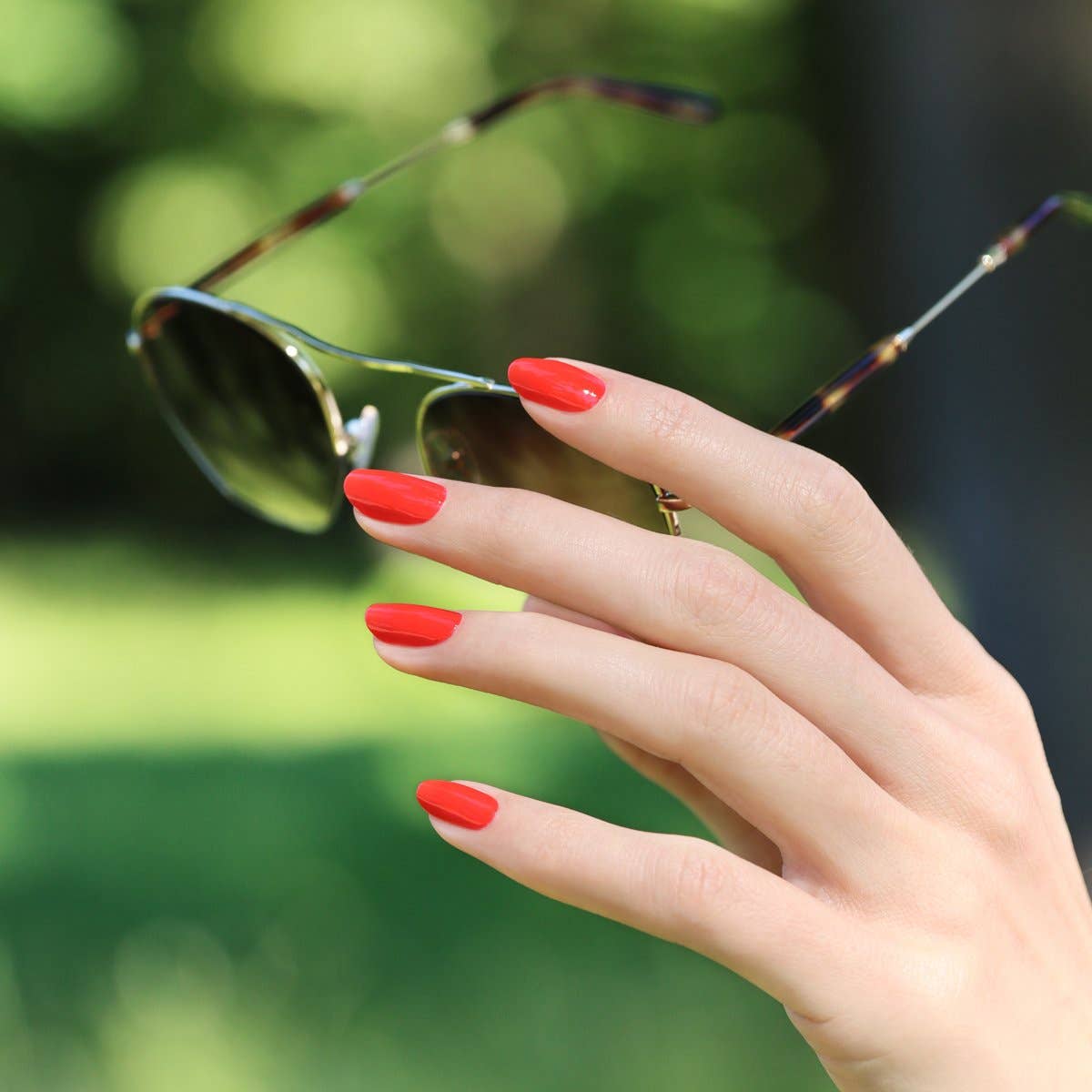 Look veraniego con el esmalte Rojo Coral de Manucurist, el accesorio perfecto para días de sol.