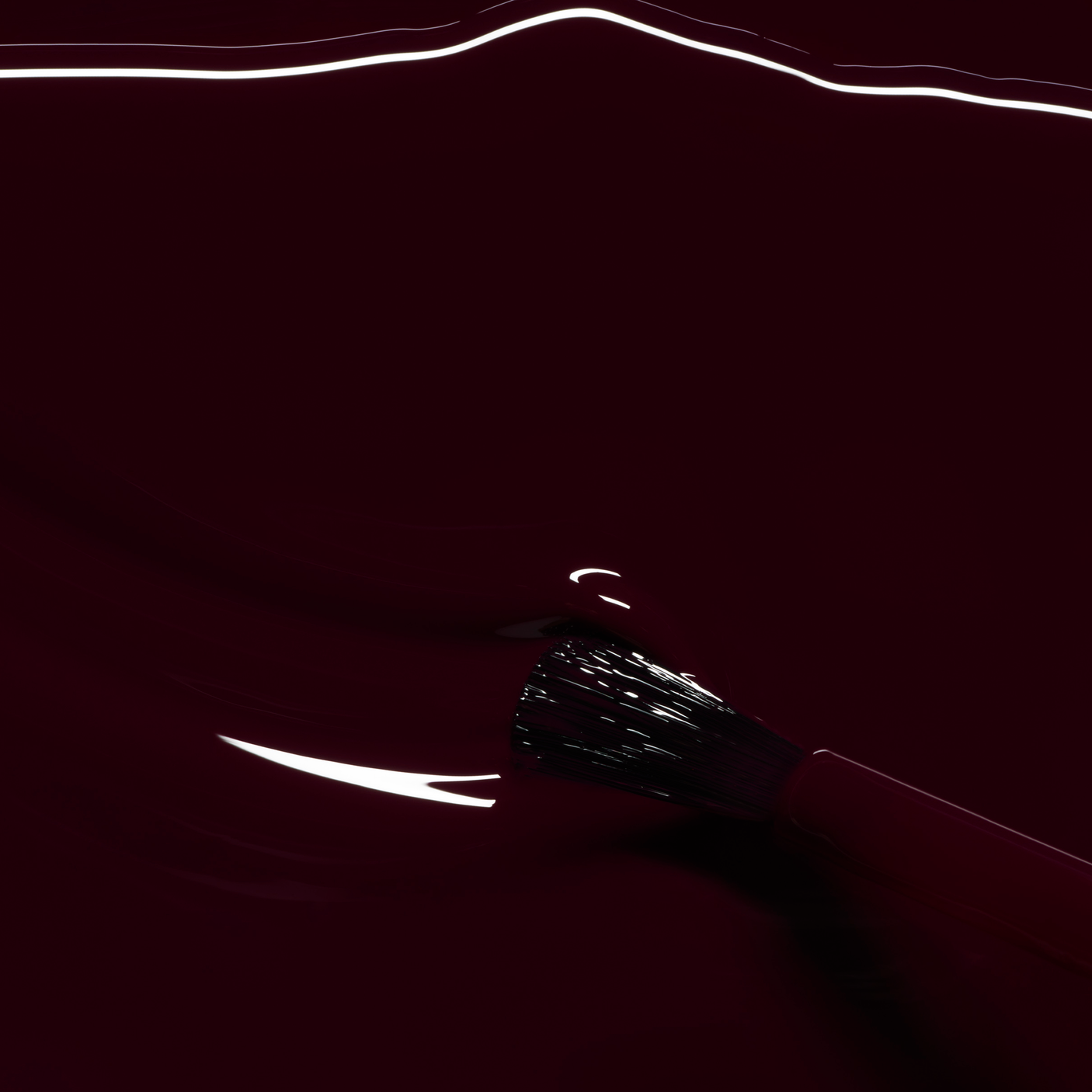 Detalle de la textura fluida y el acabado brillante del esmalte Ciruela de Manucurist sobre el pincel de precisión.