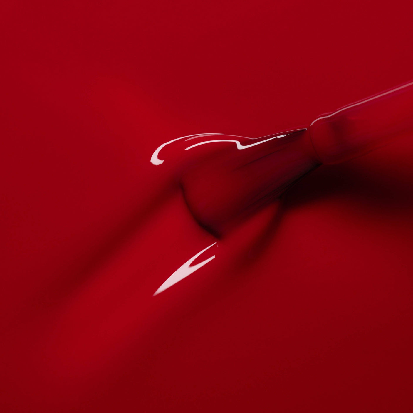 Primer plano de la textura fluida y el brillo lacado del esmalte Granada de Manucurist sobre el pincel.