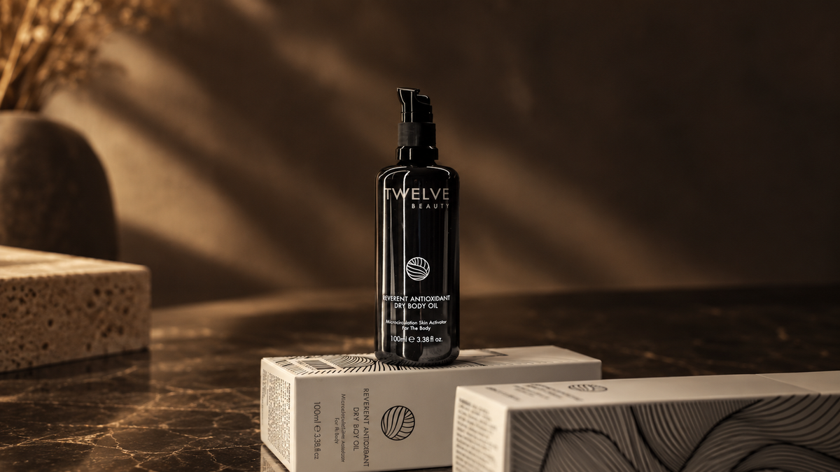 Aceite corporal Reverent Antioxidant Dry Body Oil de Twelve Beauty sobre sus cajas; ilustración editorial creada con IA.