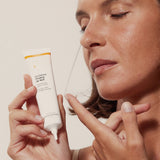 Modelo mostrando el tubo abierto de Novexpert Crema Peeling de Noche y una pequeña muestra sobre un dedo