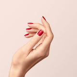 Manicura impecable en color rojo Granada con las manos naturales.