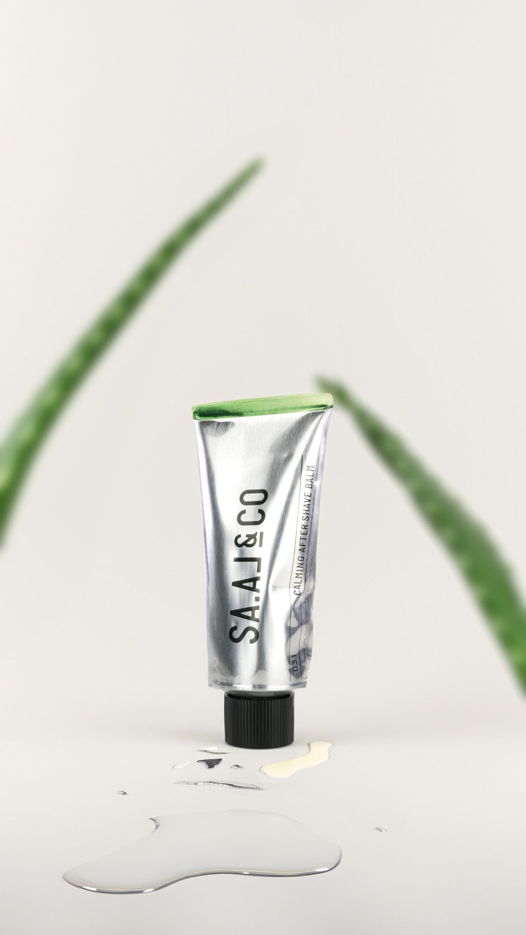 Bálsamo after shave SA.AL&CO 031 de 100 ml junto a una hoja de aloe sobre una superficie húmeda