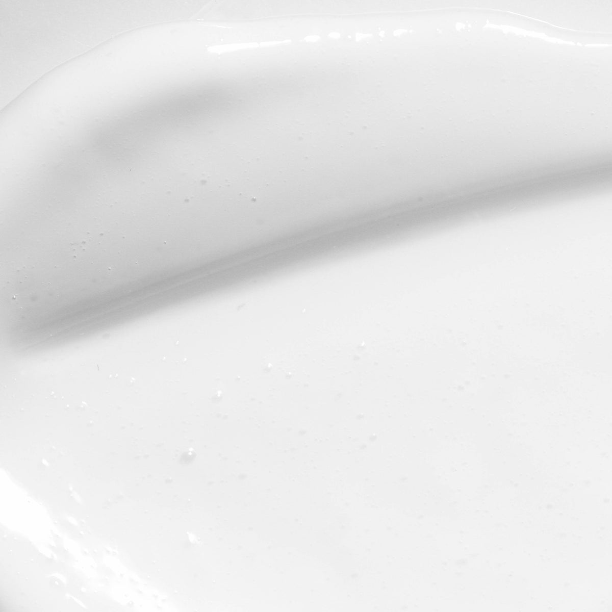 Detalle de la textura blanca de la Crema Antimanchas Novexpert extendida sobre una superficie