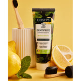 Tubo de dentífrico de carbón vegetal Coslys junto a limón, menta y cepillos de dientes