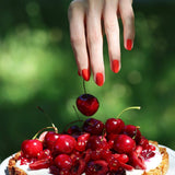Contraste vibrante de la manicura Rojo Coral de Manucurist con frutas rojas, ideal para verano.
