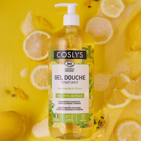 Gel de ducha Coslys Verbena y Limón con dosificador entre rodajas de limón sobre fondo amarillo