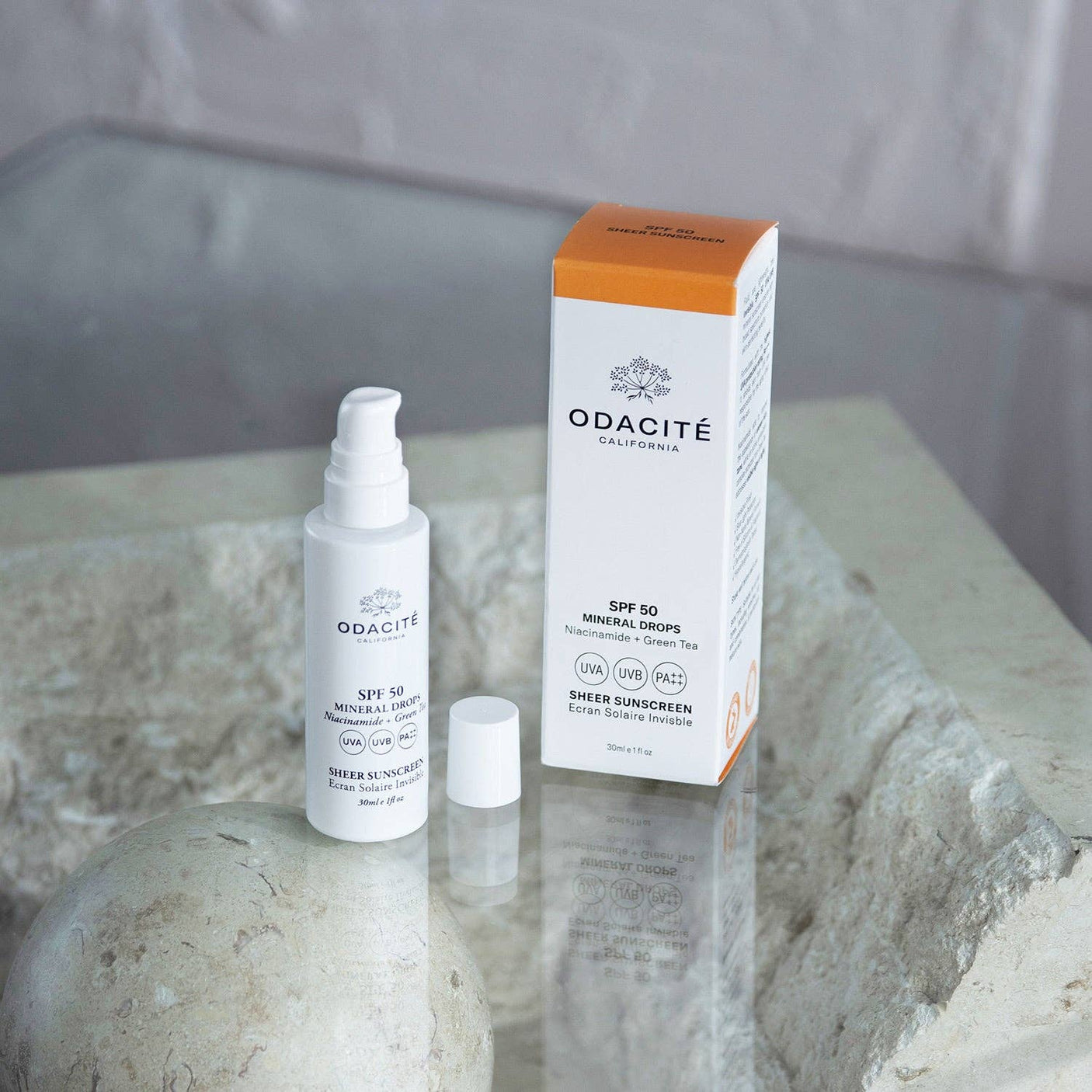 Gotas Minerales SPF 50 Odacité con caja - Foto lifestyle sobre piedra natural | Biovardi