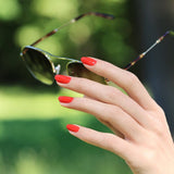 Look veraniego con el esmalte Rojo Coral de Manucurist, el accesorio perfecto para días de sol.