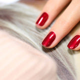 Uñas pintadas con el tono Red Hibiscus de Manucurist, un rojo sofisticado con acabado profesional.