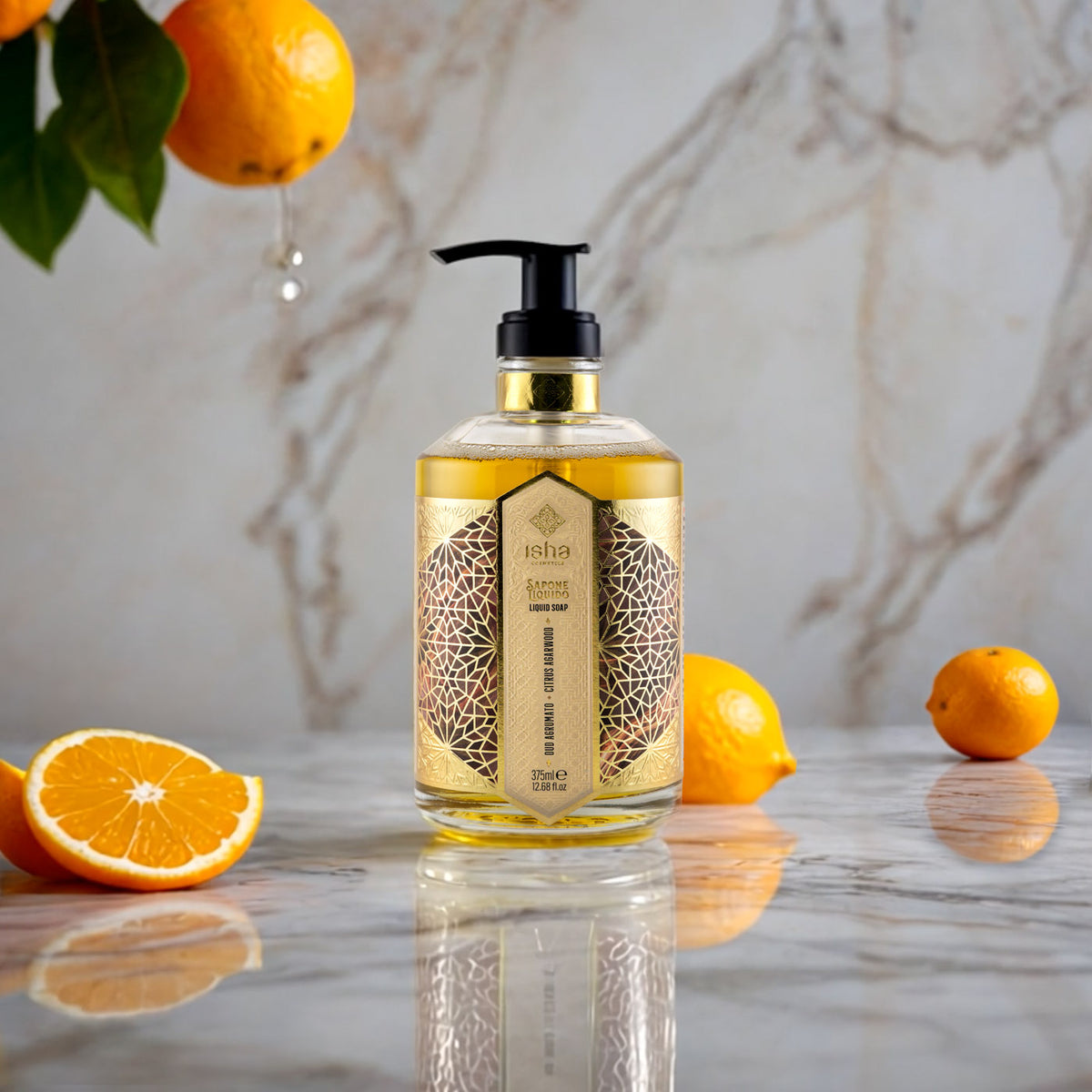 Jabón líquido ISHA Oud Agrumato de 375 ml con dosificador, rodeado de naranjas