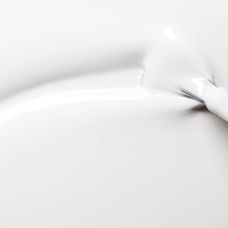 Detalle del pincel plano de Manucurist aplicando el color Nieve para una cobertura uniforme sin rayas.