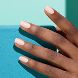 Uñas pintadas con el esmalte Bliss de Manucurist, resaltando el brillo bajo la luz del sol en pieles morenas.