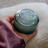 Tarro abierto de Usva Soft Glow de 50 ml sostenido en una mano