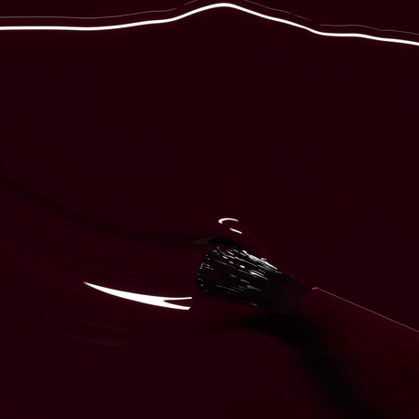 Detalle de la textura fluida y el acabado brillante del esmalte Ciruela de Manucurist sobre el pincel de precisión.