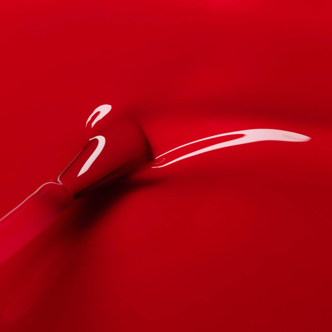 Detalle de la textura fluida y el brillo lacado del esmalte rojo Anémone de Manucurist.