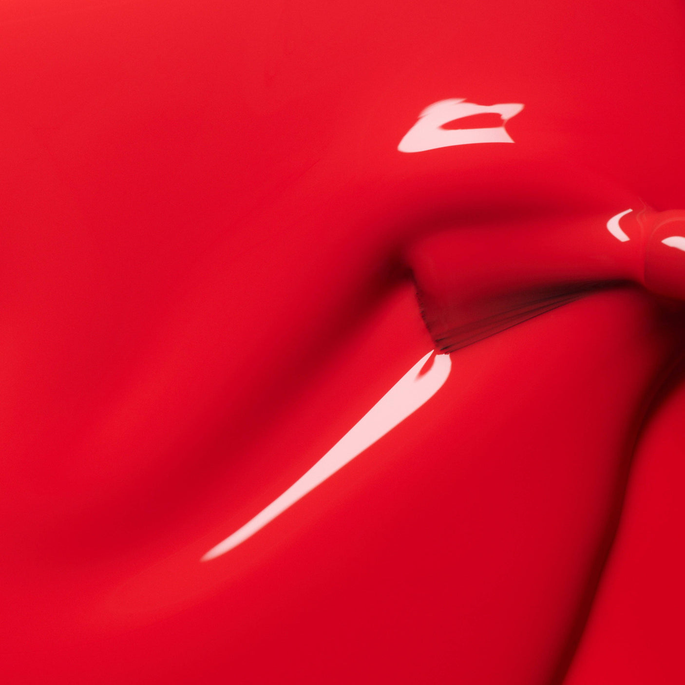 Detalle de la textura fluida y el brillo intenso del esmalte Rojo Coral de Manucurist.