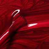 Primer plano del pincel con esmalte Red Hibiscus de Manucurist, mostrando su textura fluida y brillo intenso.