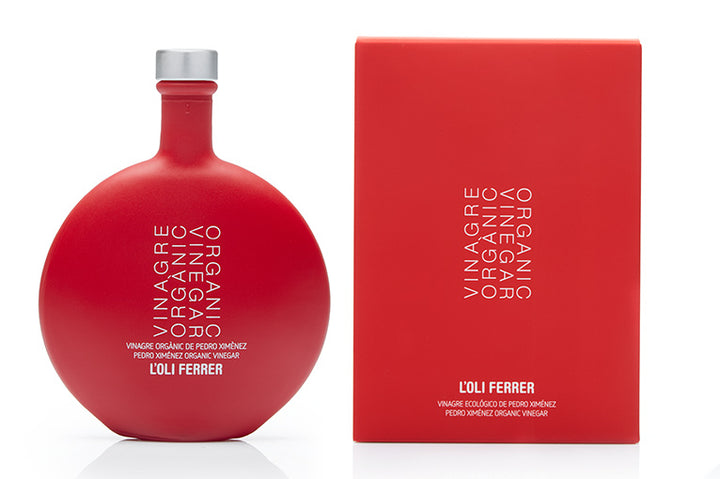 Vinagre ecológico Pedro Ximénez L’Oli Ferrer con botella y estuche rojo sobre fondo blanco